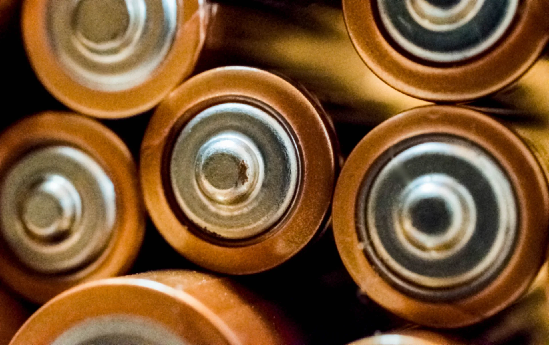 Close-up of the metal terminals of several cylindrical batteries